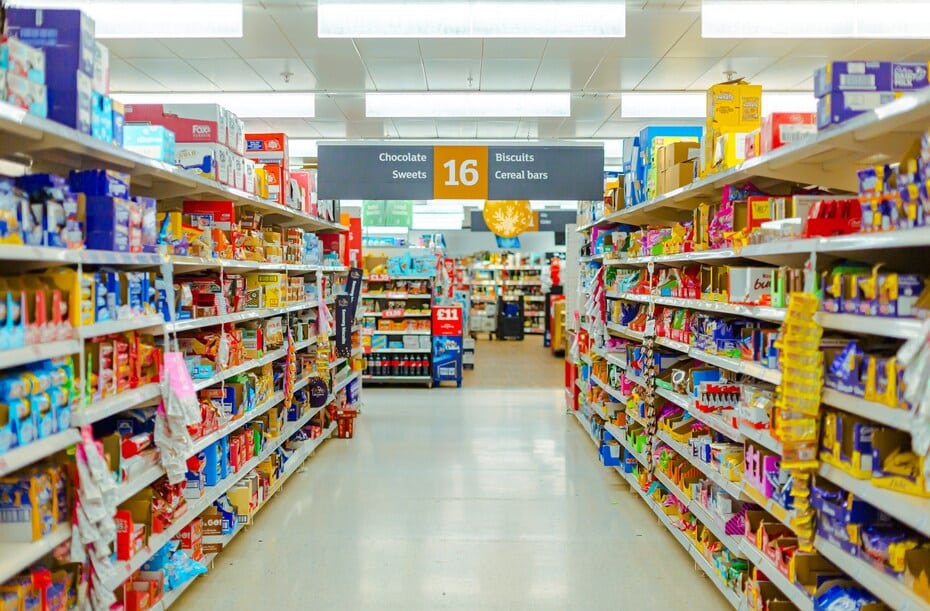 Bright supermarket aisle with shelves full of sweets and biscuits, representing accidentally vegan foods in the UK