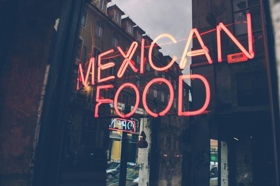neon Mexican food sign in a restaurant window, representing eating vegan in Mexico for featured blog image